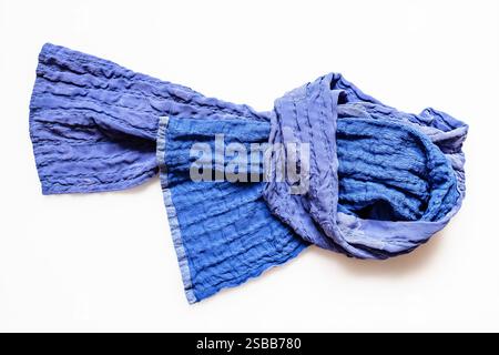 top view of knotted blue patchwork scarf sewn from stitched silk fabrics on white background Stock Photo