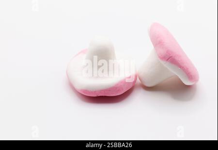 Two heart-shaped marshmallow candies in pink and white rest on a light background, creating a simple yet romantic confectionery composition. Stock Photo