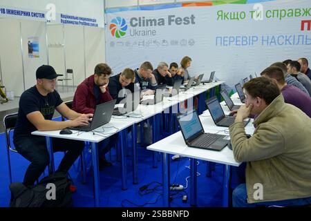Group of people, engineers, taking an exam sitting at the table in front of monitors. ClimaFest. January 12, 2020. Kiev, Ukraine Stock Photo