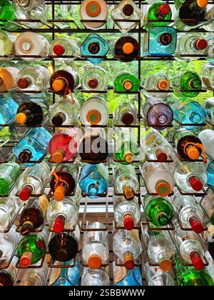 Rack of old colourful bottles in a restaurant, backlit by a window. Stock Photo