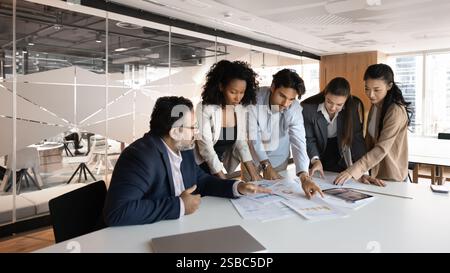 Focused diverse company employees reviewing statistic documents Stock Photo