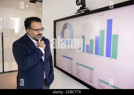 Serious senior Indian business project leader man analyzing marketing report Stock Photo