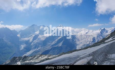 Scenic Snow-Capped Mountain Peaks Under a Clear Blue Sky in Summer Stock Photo