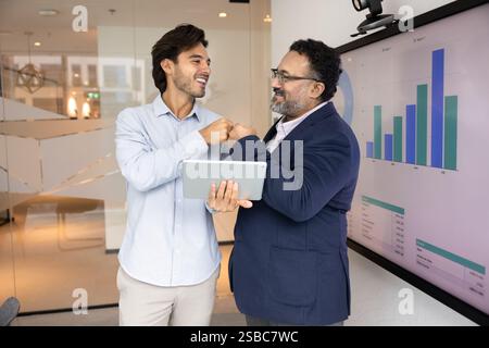 Happy different aged diverse business colleagues making fist bump gesture Stock Photo