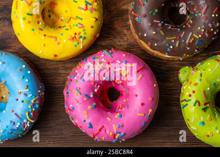 Colorful glazed donuts on wooden background. Top view Stock Photo