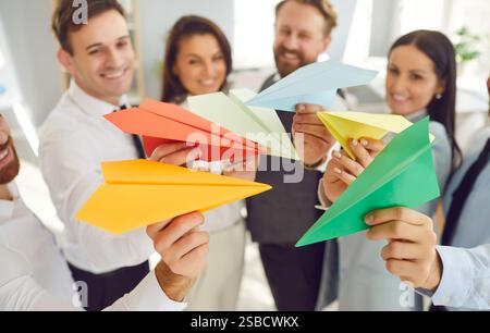 Business people with paper planes having success teamwork standing in office. Stock Photo