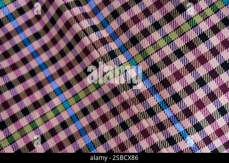 A detailed view of checkered fabric featuring pink, maroon, green, blue, and beige tones Stock Photo