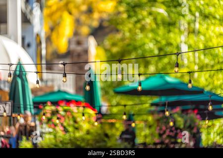 Many hanging light bulbs pattern bokeh isolated against Vail, Colorado town restaurant closeup Stock Photo