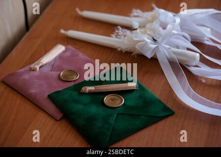 Elegant Sealed Invitations with Candles and Decorative Ribbons on a Wooden Surface. Stock Photo