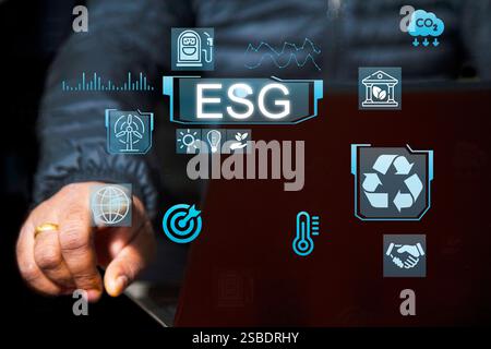 Businessman with ESG icon of saving clean energy environmental, social, governance, sustainable and corporation development, futuristic blue eco frien Stock Photo