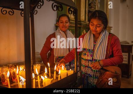 Guatemalan women lighting candles in the Cathedral of San Jose, Antigua, Guatemala Stock Photo