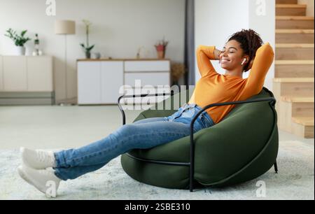 Calm black woman having rest at home on bean bag Stock Photo