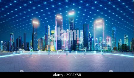 Empty parking lot with ev charging stations and glowing digital grid connecting illuminated skyscrapers at night, symbolizing smart city technology. 3 Stock Photo