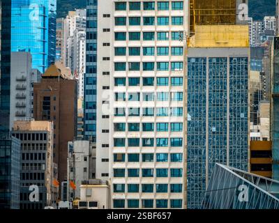A close-up view of densely packed buildings in Hong Kong, showcasing a variety of architectural styles and colors.  The image emphasizes the city's ve Stock Photo