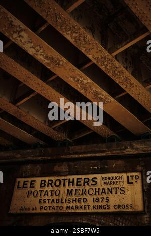 Vintage ghost sign advertising Lee Brothers Potato Merchants in Borough Market, London on a wall under a railway bridge. Stock Photo