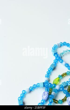 Vertical abstract background with copy space, featuring vibrant green and blue acrylic bead necklaces. Ideal for Brazilian Carnival festive costumes. Stock Photo