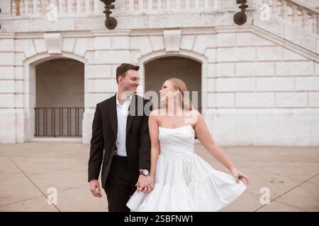 Smiling engaged couple holding hands walking at the DIA in Detroit, MI Stock Photo