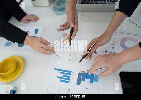 Hands of diverse professionals analyzing financial charts during a business meeting. Stock Photo