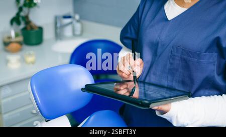 Healthcare Professional Using Tablet in Modern Dental Office Stock Photo