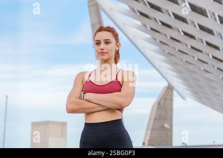 Confident Athletic Woman Posing Outdoors with Modern Architecture in Background Stock Photo