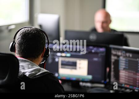 Moirans (south-eastern France): Altaë, a digital services company. Man, employee wearing headphones, in front of his computer with dual monitors Stock Photo