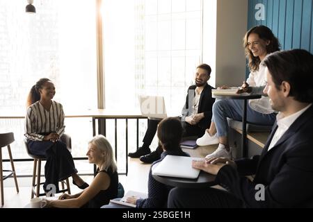 Six professionals engaged in lively informal meeting in modern office Stock Photo