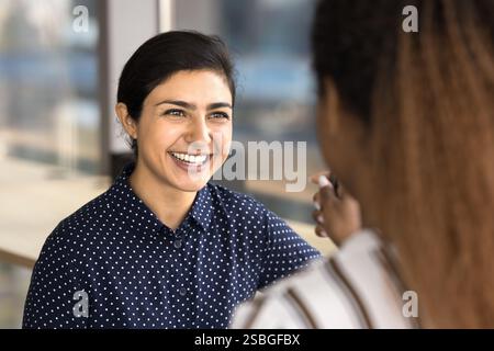 Indian woman employee enjoy pleasant friendly conversation with teammate Stock Photo