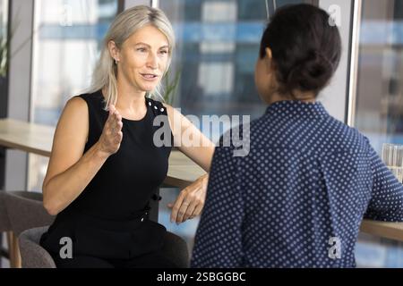 Attractive middle-aged woman boss gives instructions to female secretary Stock Photo