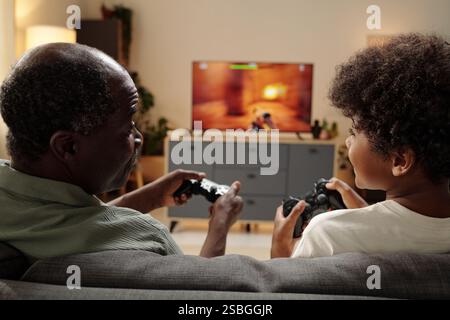 Elderly Black Man Playing Video Games with Child Stock Photo
