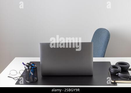 Laptop computer, notebook, and eyeglasses and headphones on a desk, place for work and study, home freelancer's office, no people Stock Photo
