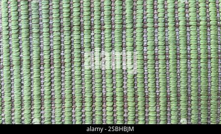 Close-up of a green woven fabric featuring intricate patterns and textures. Stock Photo
