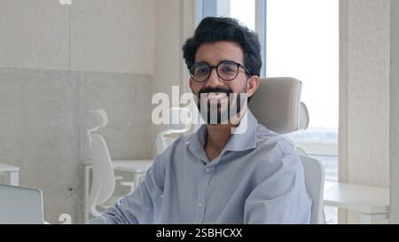 Arabian Indian businessman professional entrepreneur software engineer employer working on laptop in office workplace typing business project startup Stock Photo