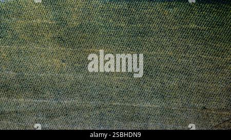 Close-up of textured fabric showcasing a blend of green and brown hues. Stock Photo