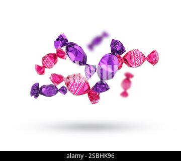 Candies in bright wrappers falling on white background Stock Photo