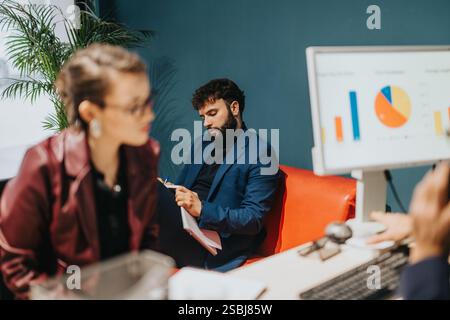 Team Members Collaborating and Analyzing Data in a Modern Office Setting Stock Photo