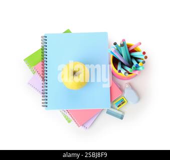 Notebooks, apple and different stationery isolated on white, top view Stock Photo
