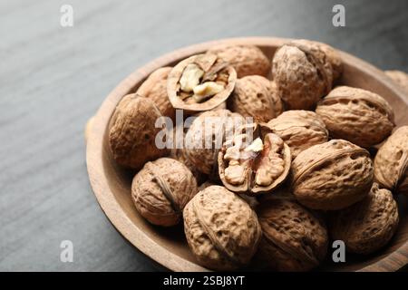 Fresh ripe walnuts in shells on black table, closeup Stock Photo