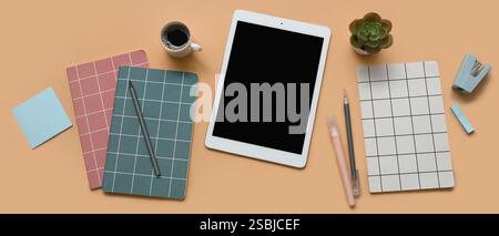 Tablet computer, cup of coffee and stationery on brown background Stock Photo
