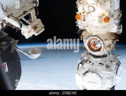 The shadow of the Moon, caused by a solar eclipse over Antarctica, is viewed from the International Space Station in orbit above the south Atlantic Ocean on December 4, 2021. The Russian Prichal module attached to the Nauka multipurpose docking module on the space station can be seen in the foreground. Stock Photo