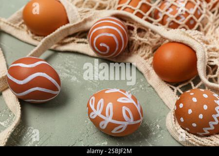 String bag with painted Easter eggs on grey background Stock Photo