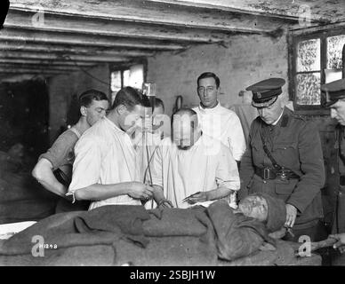 Members of the 2nd NZ Field Ambulance, injecting gum infusion into a patient. New Zealand. 1914-1918. World War One.  Henry Armytage Sanders. Alexander Turnbull Library, Wellington, New Zealand. Stock Photo