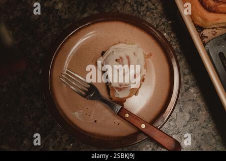 Close-Up of Cinnamon Roll on Plate with Fork Stock Photo