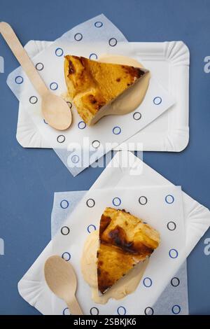 Oozing Cheesecake on a paper plate on a white table Stock Photo