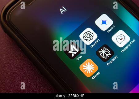 Grok AI, ChatGPT, Google Gemini, Claude, Perplexity, and Hugging Chat apps are shown on an iPhone. Modern generative AI chatbot service concept image. Stock Photo
