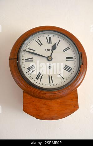 Vintage wooden round clock LNER with Rome numbers on white background. Stock Photo