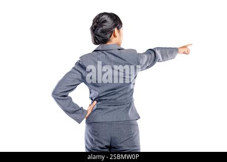 Portrait rear view of an Asian businesswoman standing with a pointing hand gesture isolated over a white background. Copy space. Concept of business, Stock Photo