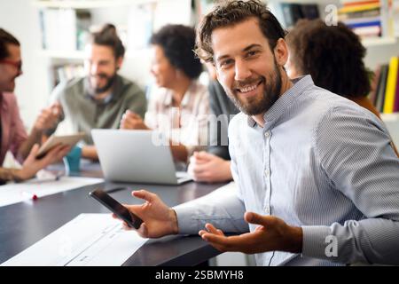 Diverse employees gathered in the office having fun during brainstorming while discussing new ideas Stock Photo