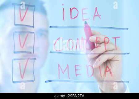 Businesman drawing conceptual checklist on glass screen. Business and social media concept. Close up Stock Photo