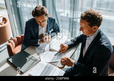 High angle view of businessman explaining contract to client at office Stock Photo