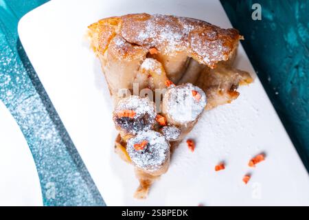 A slice of banana pie or tart on a white plate on a turquoise background. French dessert close-up. High quality photo Stock Photo